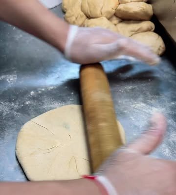 Rolling aloo parathas for a 100-piece bulk order